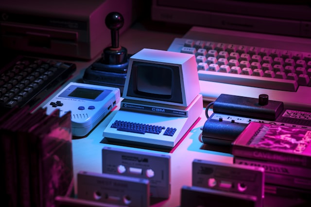 Gaming consoles and computers glowing under neon light